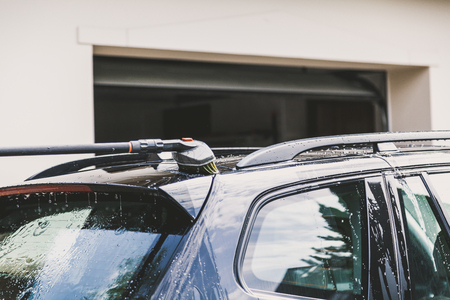 Washing the black car with a special brush on the long handleの写真素材