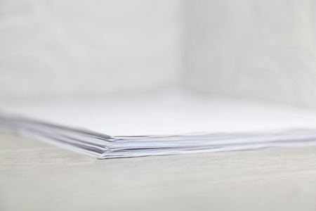 stack of paper sheets lies on the desktop in the cornerの写真素材