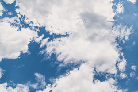 High white fluffy clouds in the blue sky of a summer day