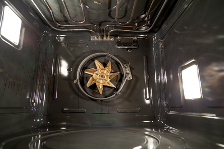 How an electric oven is arranged from the inside on the back wall of a fan gear with blades. Electric heaters are located on top.の写真素材