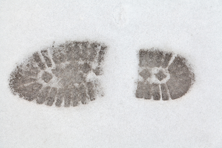 Footprints in the snow. Clear tread imprint on the sole of the boot on white snowの写真素材