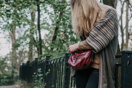 woman with her hair straightens bag in a city park clear dayの写真素材