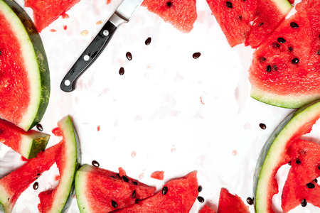 Several slices of ripe red watermelon are randomly laid out on a white background close-up.の写真素材