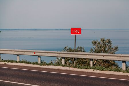 Road sign of national route number. Information sign installed on the side of a bridge across a wide...