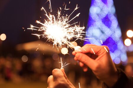 Chain Reaction Bengal Lights. Bengal lights in male hands set fire to each other on Christmas tree...