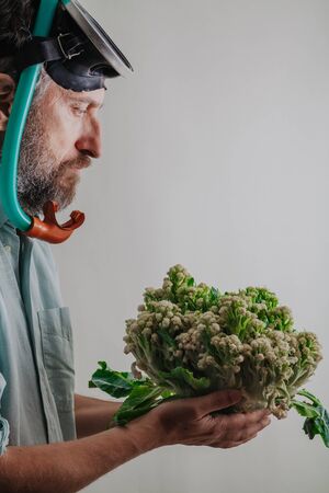 Cauliflower or coral. Comic story. A man with a beard and a swimming mask holds a cauliflower head in his hand like sea coralの写真素材