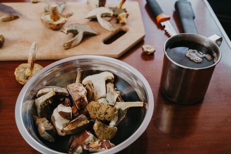 Still life with mushrooms. Sliced edible mushrooms lie in a round plate. Nearby is a cup of teaの写真素材