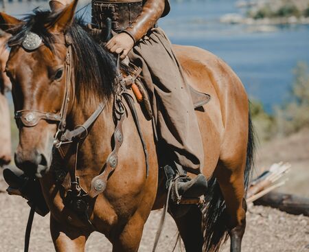 warrior in broad trousers sits on the back of a beautiful red horse