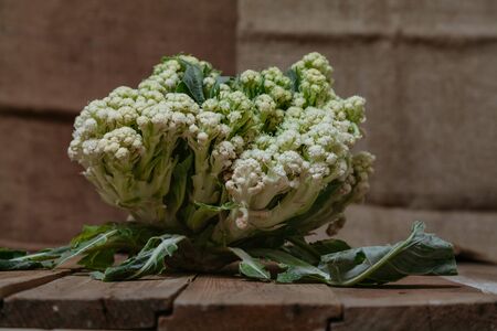 Autumn still life. Cauliflower head on the old planed wooden boards closeupの写真素材