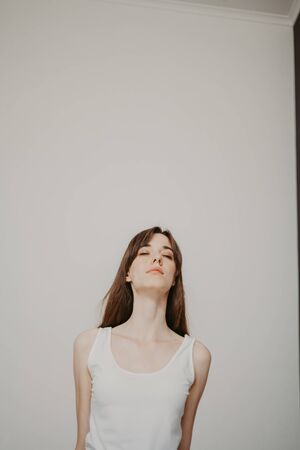 Cute graceful girl with long hair in tights engaged in yoga on a lilac rugの写真素材