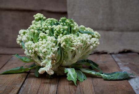 Autumn still life. Cauliflower head on the old planed wooden boards closeupの写真素材