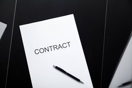 Transparent contract. A contract printed on paper and a pen lies in a glass box close-upの写真素材