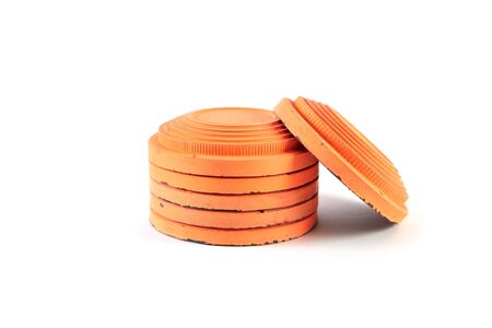 Several round orange targets of cymbals are stacked on a white background. One plate stands sideways. Close-upの写真素材