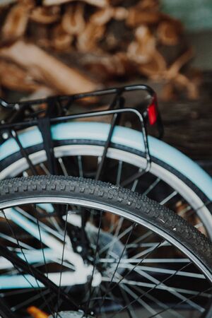 Two bicycles stand nearby in a garage. The rear wheel of a modern bicycle close-up. Behind another bikeの写真素材