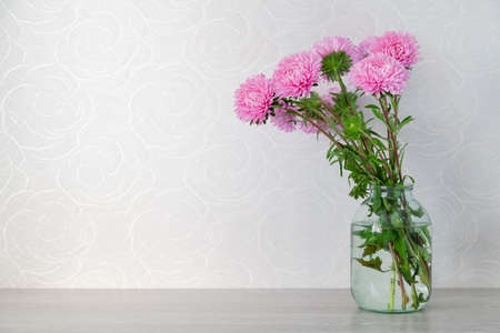 bouquet of pink chrysanthemums in a glass vase on a white background close-up
