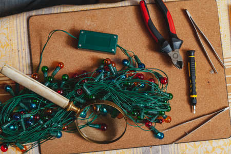 Christmas garland and tool. A twisted garland with round bulbs lies on the table. Nearby are a...