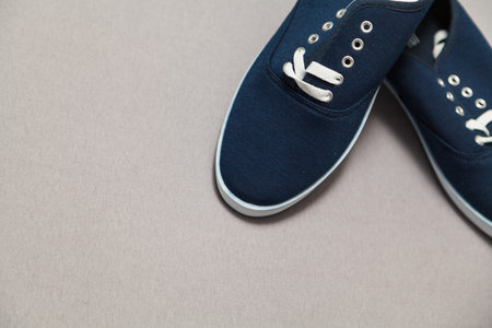 Two new blue sneakers with white soles and laces stand on a white isolated background.