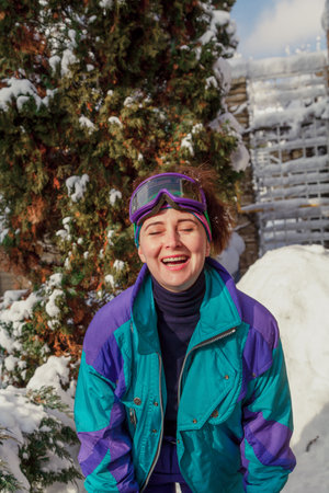 Beautiful young woman in ski overalls. On the head are sports glasses. A female portrait without...