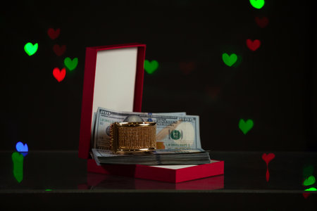 Valentine's Day gift. An open red gift box stands against a dark background. It contains a bundle of...