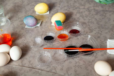 On the home table, a creative mess was lit when painting Easter eggs. Paints and tools of the artist...