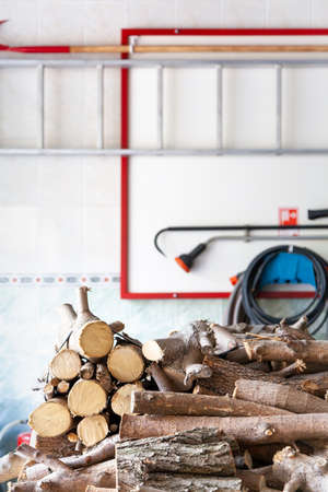 pile of sawn firewood of circular cross section are piled up in a pile. In the background is a white...
