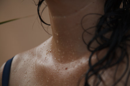 Close-up of water drops are visible on the neck of a woman with wet hairの写真素材