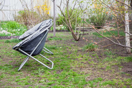 Camping. Two portable folding soft chairs stand side by side on the green grass in the yard