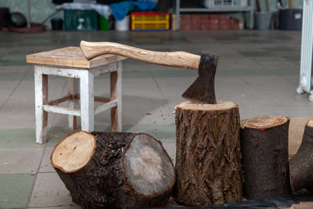 ax sticks out in a stump in the garage. There are stumps of different heights nearby