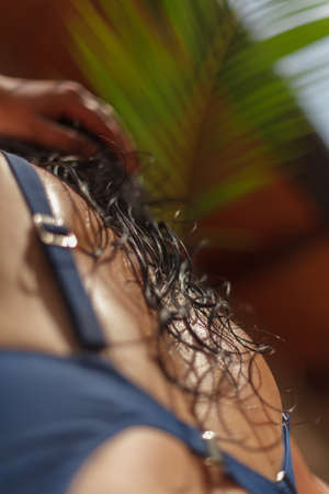 Wet long dark hair lies on the wet back of a woman in a swimsuit. Bottom viewの写真素材