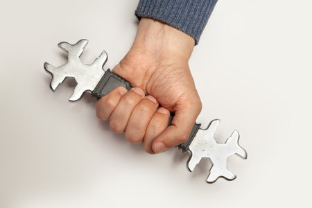 Hand holds firmly open-end wrench with metric and US standard on white backgroundの写真素材