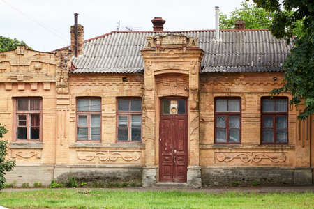 Old one-storey house with wooden windows and a narrow wooden door