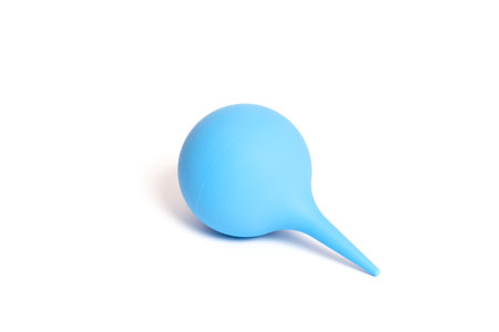 A blue hygienic syringe with a soft tip lies on a white backgroundの写真素材