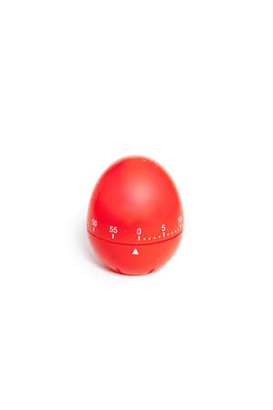 Timer for measuring time intervals in the form of a red plastic egg on a white backgroundの写真素材