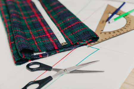 Still life on the sewing pattern. On the paper sheet drawn silhouette of a garment. On top is a piece of cloth, scissors and a flexible centimeter.の写真素材