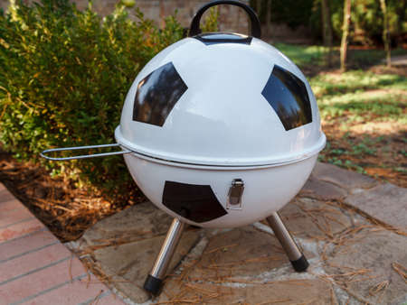 Football picnic. The original brazier in the form of a soccer ball stands on brickwork in the yardの写真素材