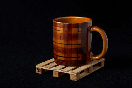 Brown cup on a small euro pallet on a black felt backgroundの写真素材