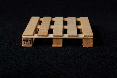 Mini version wooden pallet euro type souvenir toy on black felt background