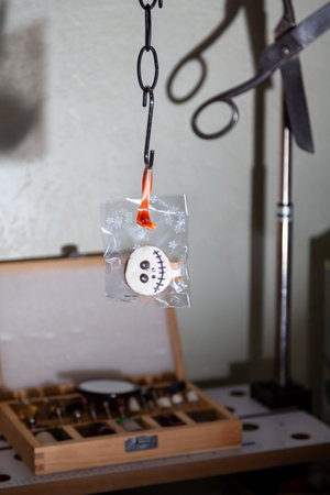 transparent Halloween cookies weigh on a steel hook. Vintage scissors hanging on the back of the...