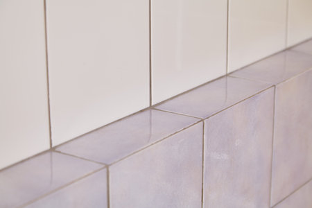 Slim gray tile shelf. Vertical wall lined with white tilesの写真素材