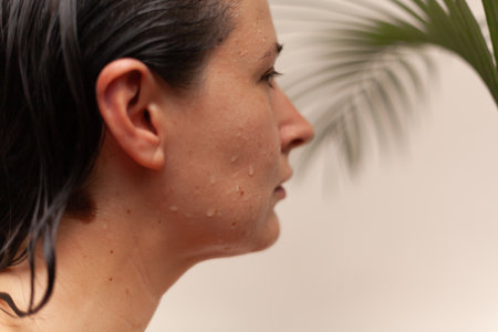 Portrait of a pretty Slav woman with water drops on her face. Blurred green palm branch in the backgroundの写真素材