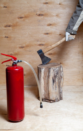 A hand in a white glove stuck an ax into a stump against a background of light-colored plywood....