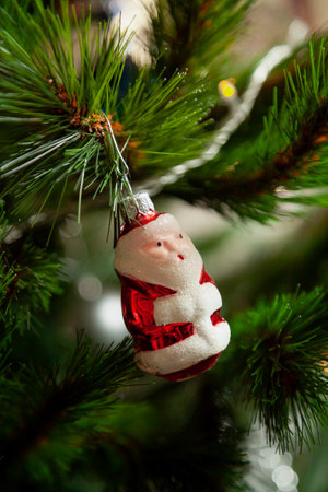 The original Christmas tree toy glass figurine of Santa Claus in a red fur coat weighs on the Christmas treeの写真素材