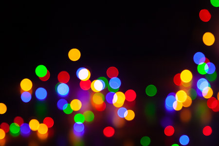 Regularly round shaped bright lights are arranged in a chaotic manner on a black background. Abstract cluster of light spots. Empty black field for descriptionの写真素材