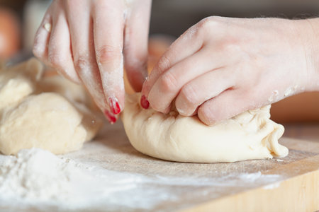 Female hands holding the halves of a raw pie together close-upの写真素材