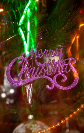 Lilac inscription Merry Christmas on an abstract blurred background. Blurred illumination lights hang in the backgroundの写真素材