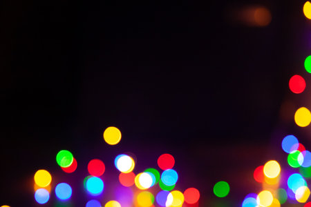 Regularly round shaped bright lights are arranged in chaotic manner on black background. Abstract cluster of light spots at bottom of frame. Empty black field at the top for an inscriptionの写真素材
