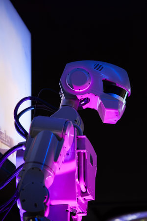 A mechanical cyborg robot with a large, oblong head on a black background.