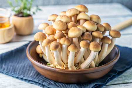Bunch of brown beech mushrooms in a bowl on a wooden tableの素材