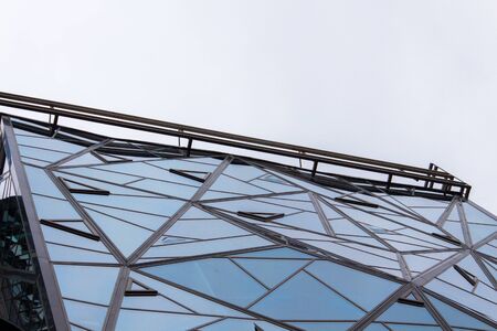 Glazed facade of the building of triangular pieces of glass. Bottom view.