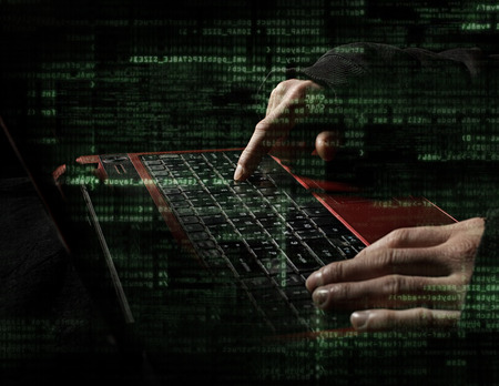  hacker hands with binary codes on monitor